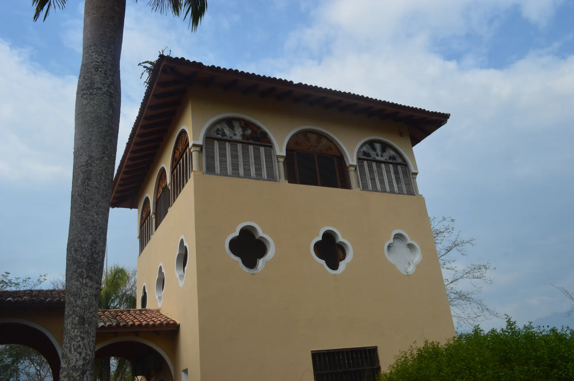 Torre de la casa de Finca Cactus con ventanas en arco y aberturas en forma de trébol